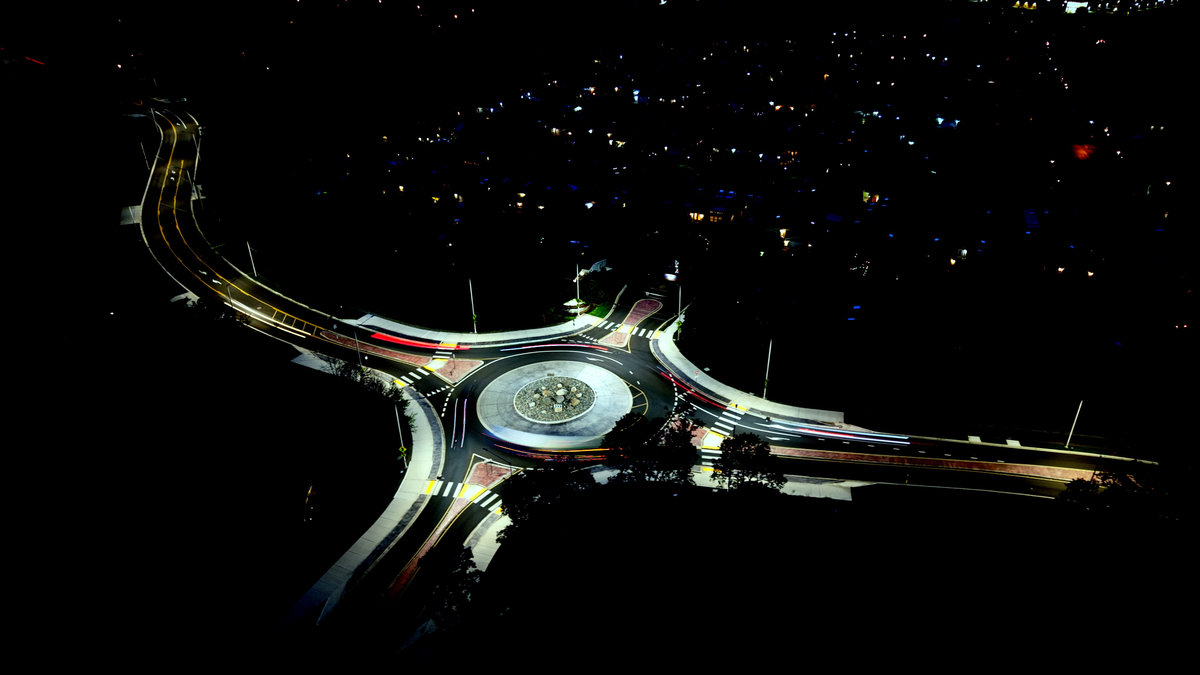 Night drone hyperlapse — car light streaks circling a roundabout, shot with a DJI Air 3S.